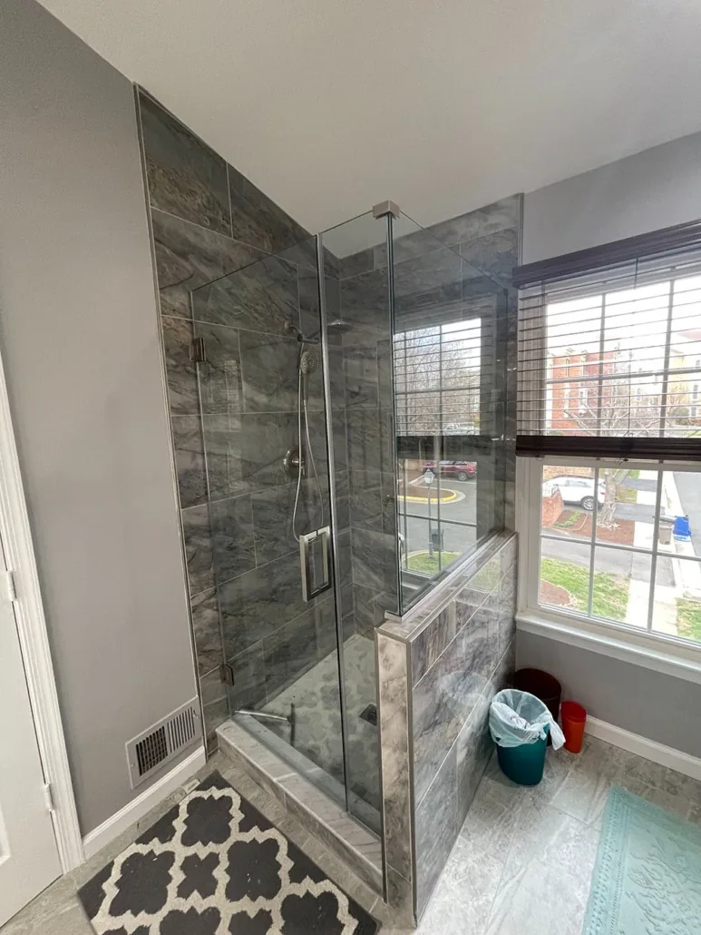 Completed bathroom with glass shower enclosure and tiled walls
