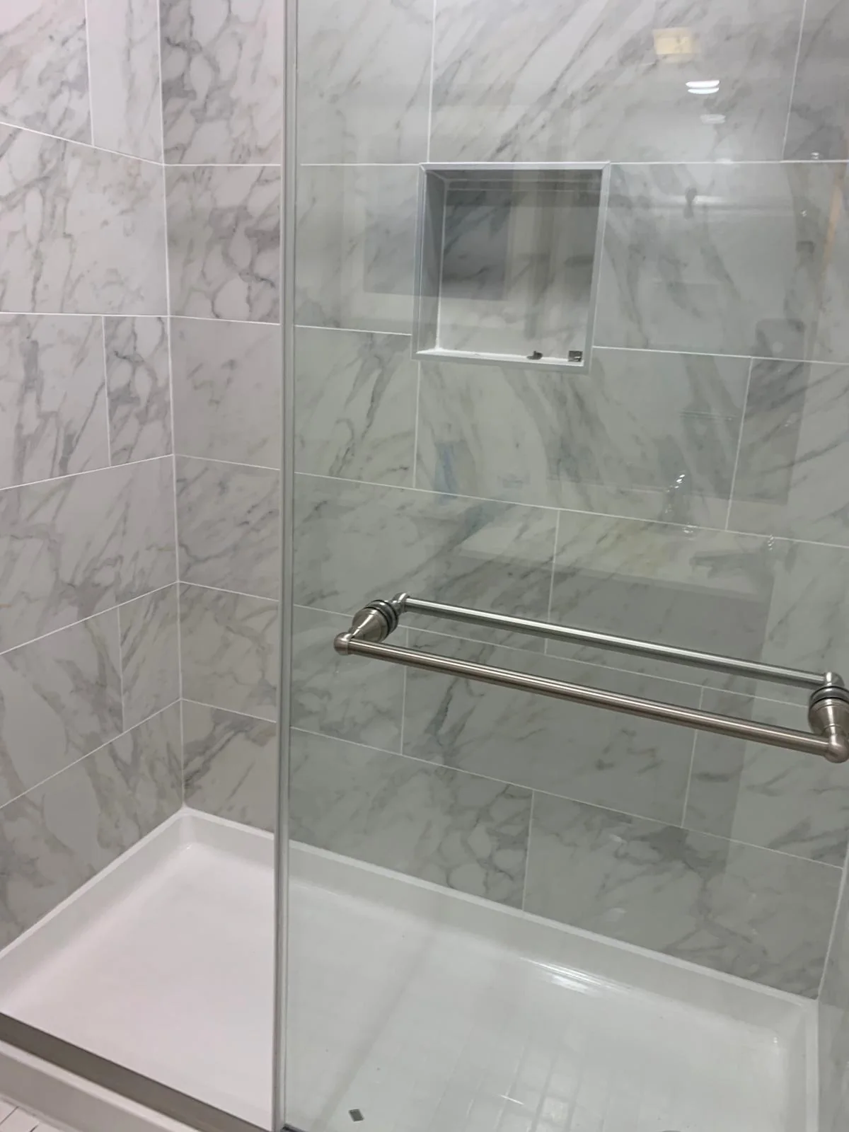 Bathroom glass shower enclosure with marble-look wall tile