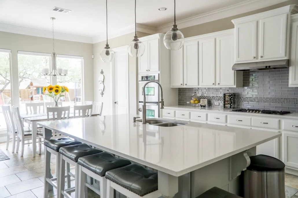 Bright completed kitchen with white cabinetry and a central island