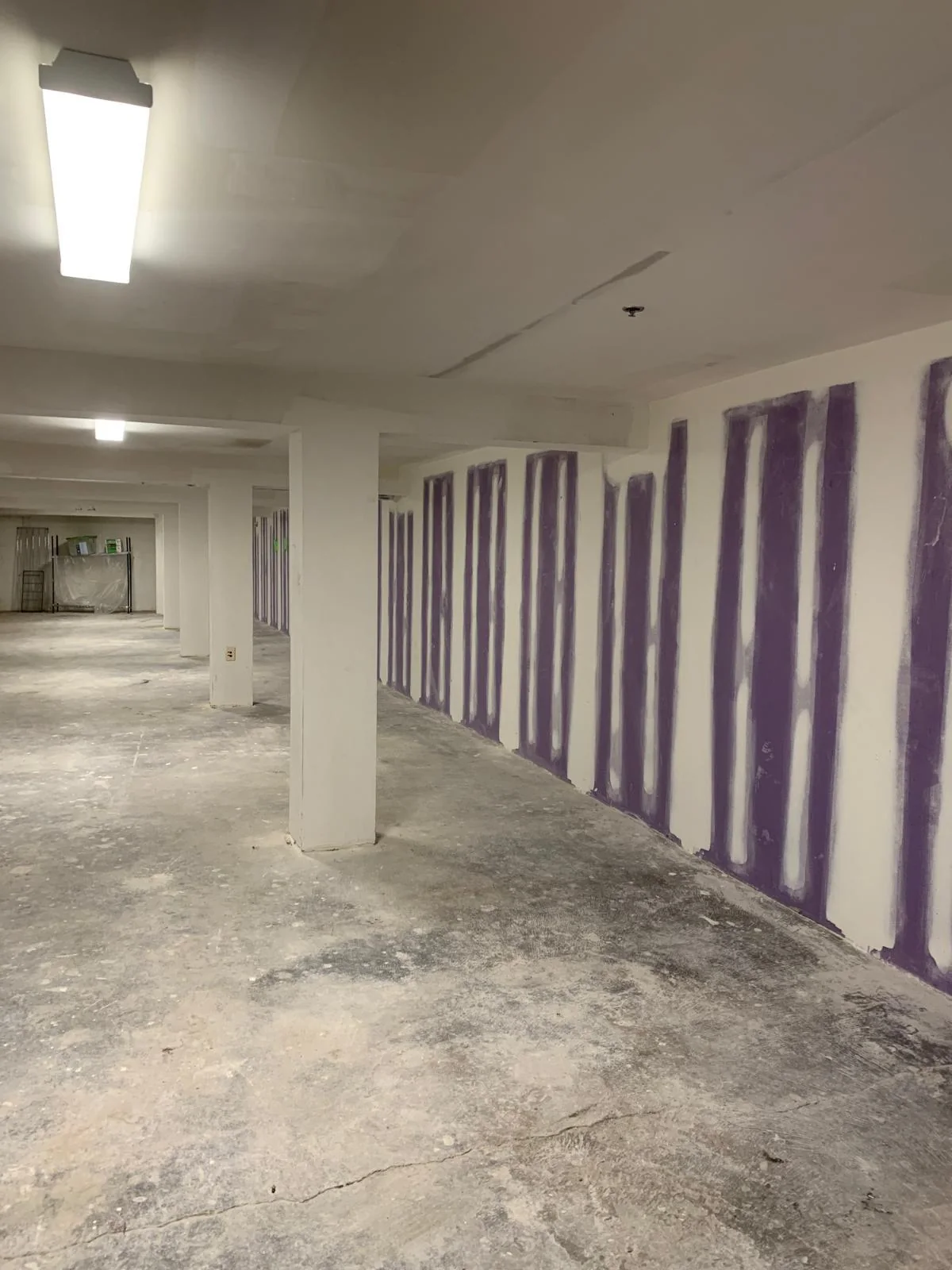 Large commercial interior with taped drywall seams and unfinished flooring