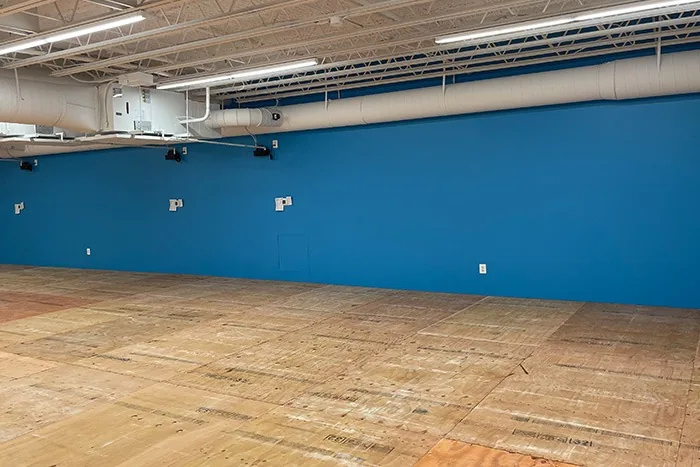 Commercial open space with finished blue accent wall and exposed ceiling