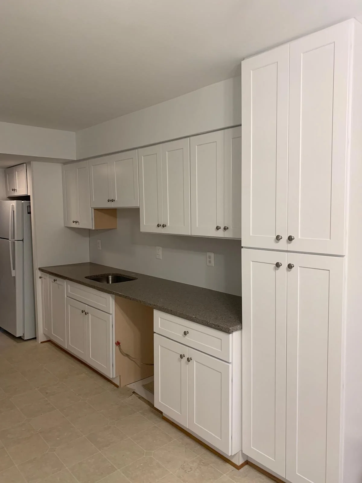 Compact white kitchen with updated cabinetry, counters and appliances
