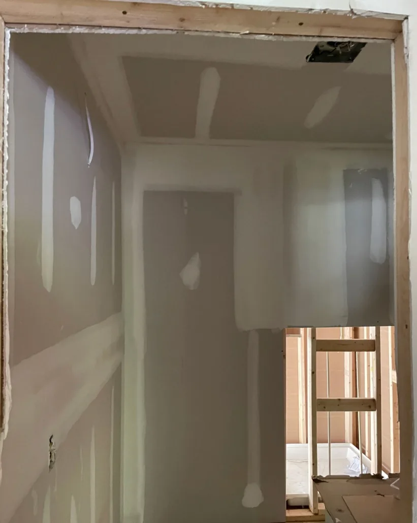 Hallway with newly installed drywall and joint compound