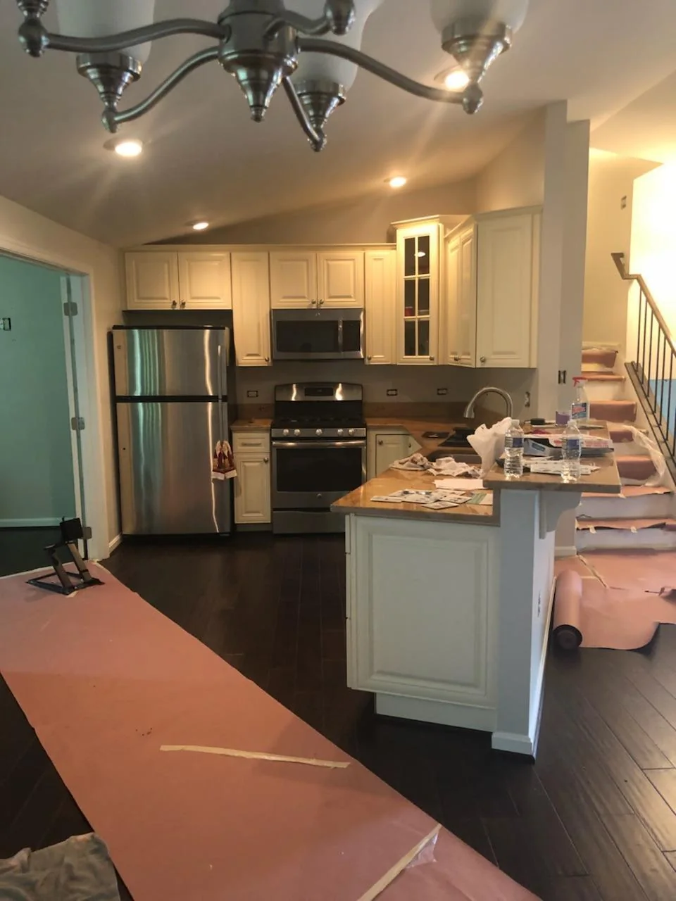 Kitchen renovation in progress with work area and protected flooring