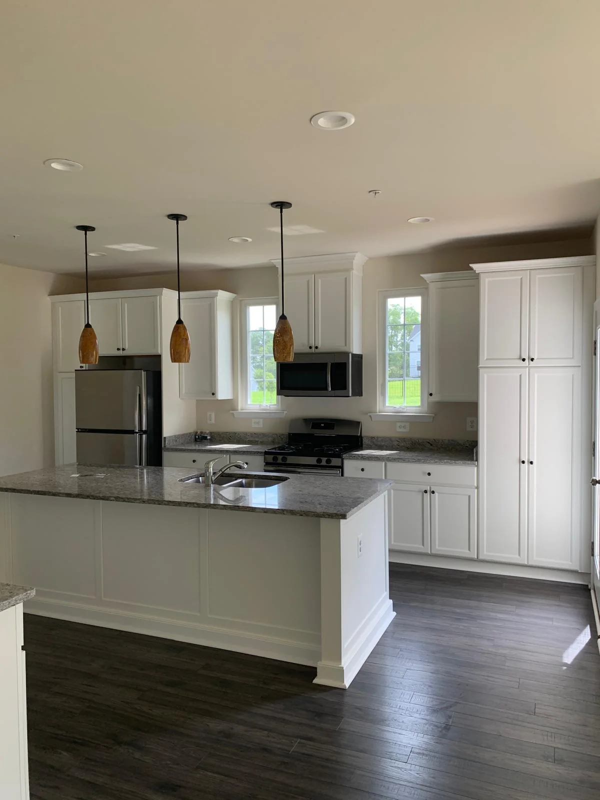 Alternate view of modern white kitchen with island and pendant lighting