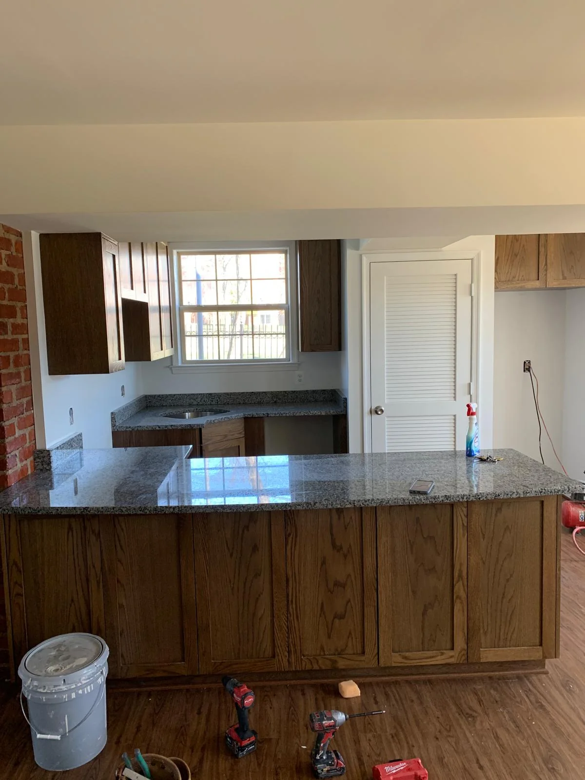 Front view of wood kitchen peninsula with stone countertop