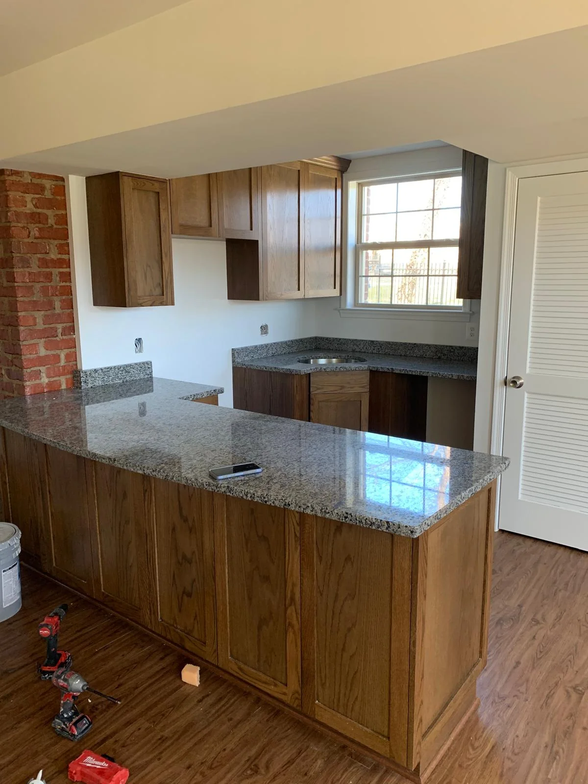 Wood-cabinet kitchen with large peninsula during renovation work