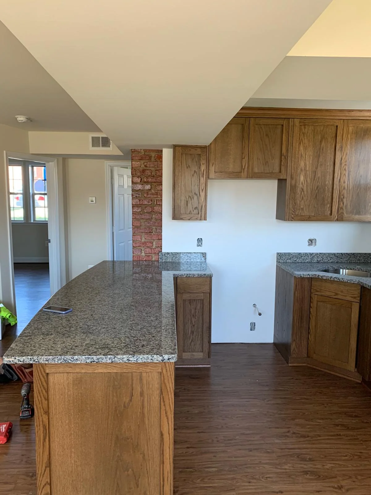 Wood-cabinet kitchen showing peninsula, flooring and open layout